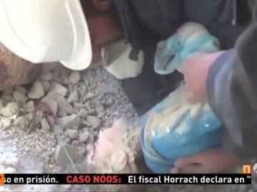Frame 44.9 de: Voluntarios y vecinos rescatan de entre los escombros a una niña que había quedado sepultada en su casa tras un bombardeo en Siria