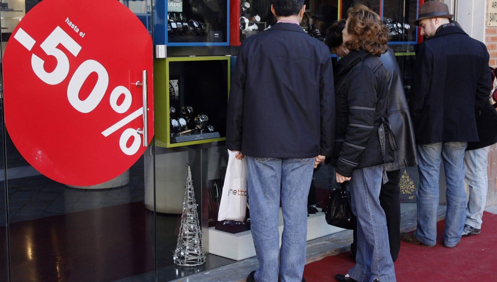 Varias personas delante de un escaparate en rebajas