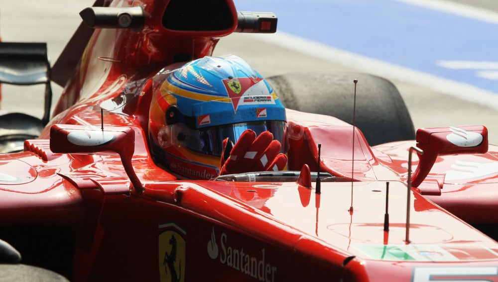 Alonso, subido en su Ferrari