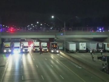 Varios camiones se alinean debajo de un puente para evitar un suicidio