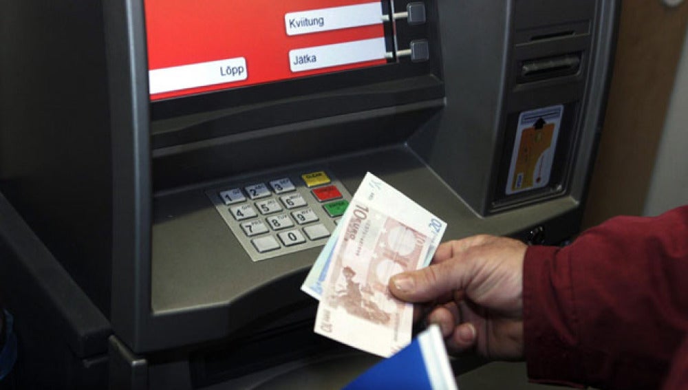 Un hombre saca billetes de euros en Tallín, Estonia