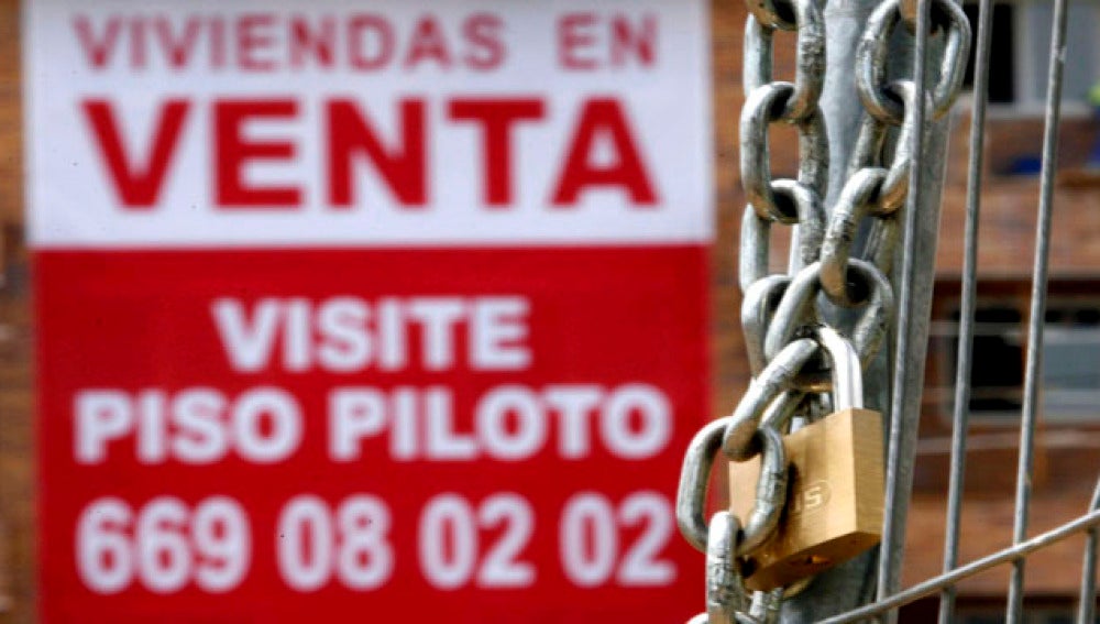 Un cartel anunciador de venta pisos cuelga de una fachada de una nueva promoción en Madrid.