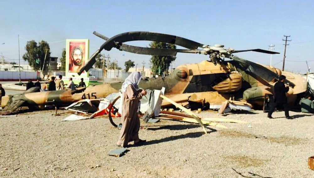 Sodados iraquíes revisan un helicóptero abatido en confrontaciones con EI
