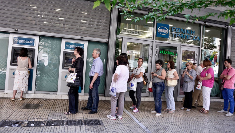 Ciudadanos griegos tratan de sacar dinero en un cajero de Atenas
