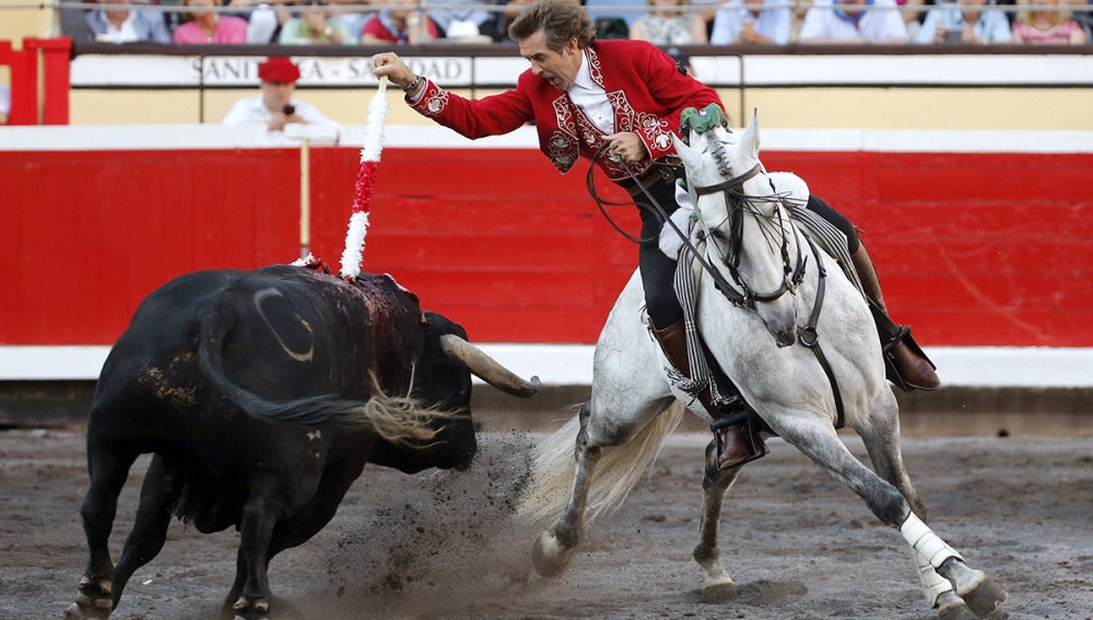 El rejoneador Pablo Hermoso de Mendoza pone una banderilla a su segundo toro en la primera corrida de abono de la Feria de Bilbao