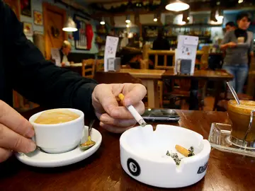 Un hombre fuma en un bar Un hombre fuma en un bar