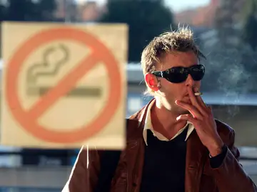 Un hombre fumando un cigarro Un hombre fumando un cigarro