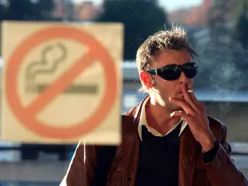 Un hombre fumando un cigarro Un hombre fumando un cigarro