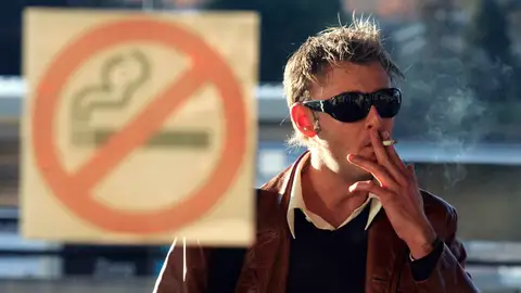 Un hombre fumando un cigarro Un hombre fumando un cigarro