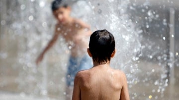 Niños se bañan para soportar el calor