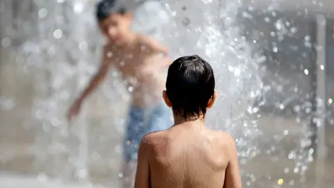 Niños se bañan para soportar el calor Niños se bañan para soportar el calor