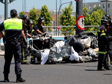 Policías y bomberos recogen los restos del vehículo arrollado