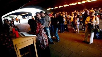 Decenas de personas hacen cola para firmar en el libro de condolencias instalado en el túnel de la tragedia