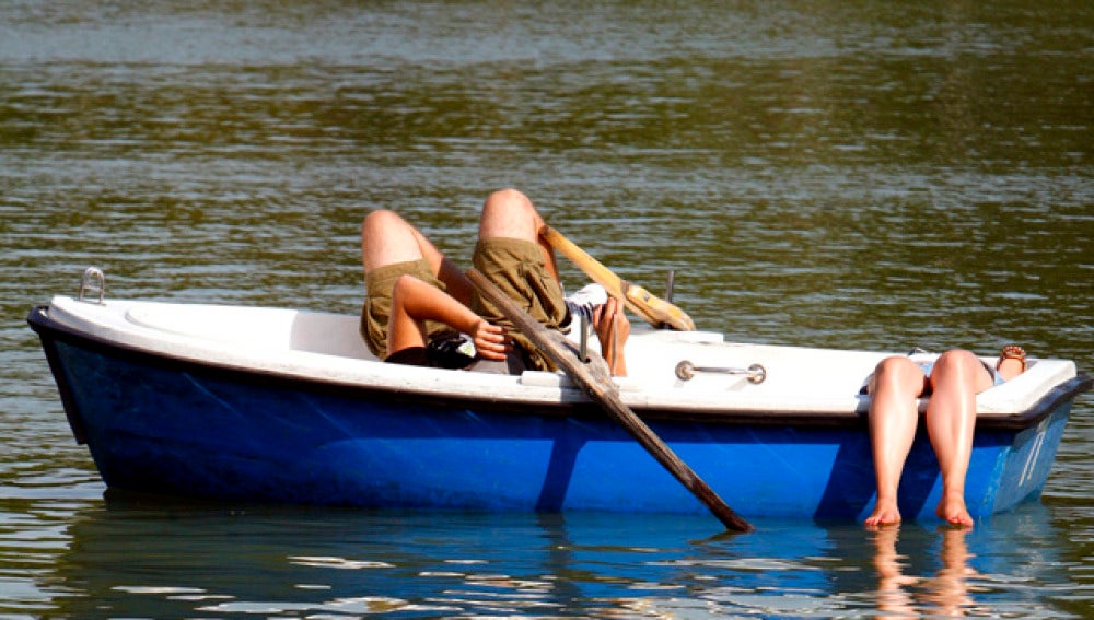 Dos madrileños palían el calor en el Retiro