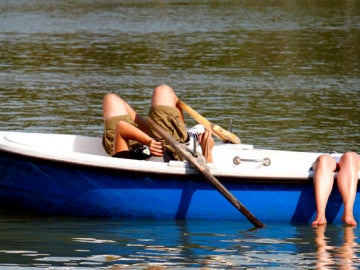 Dos madrileños palían el calor en el Retiro