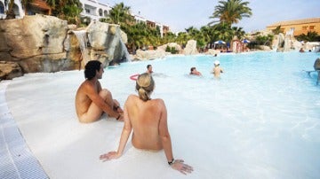 Una pareja nudista en una piscina