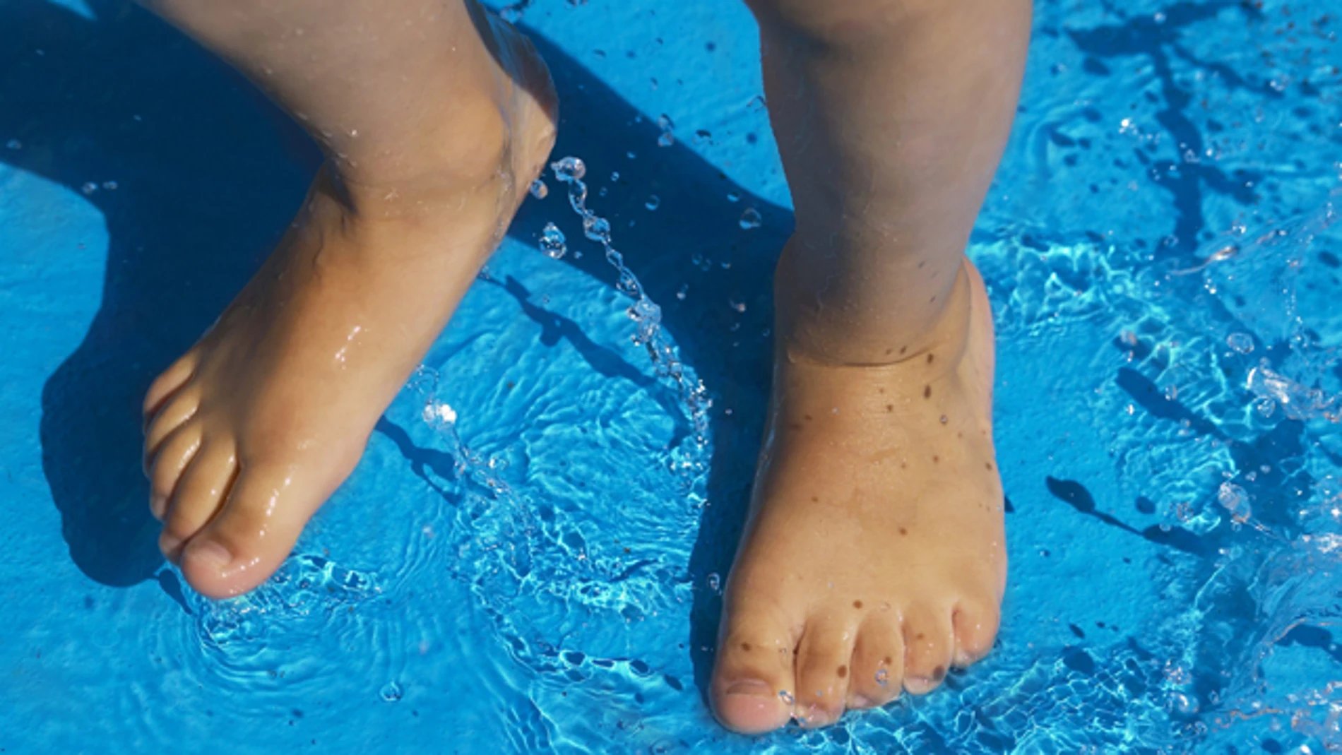 Un niño se baña en una piscina Un niño se baña en una piscina
