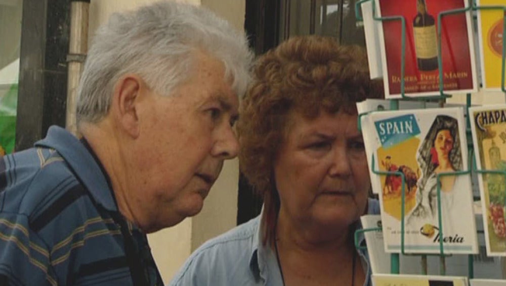 Dos turistas comprando postales