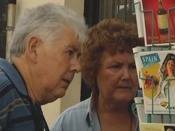 Dos turistas comprando postales Dos turistas comprando postales