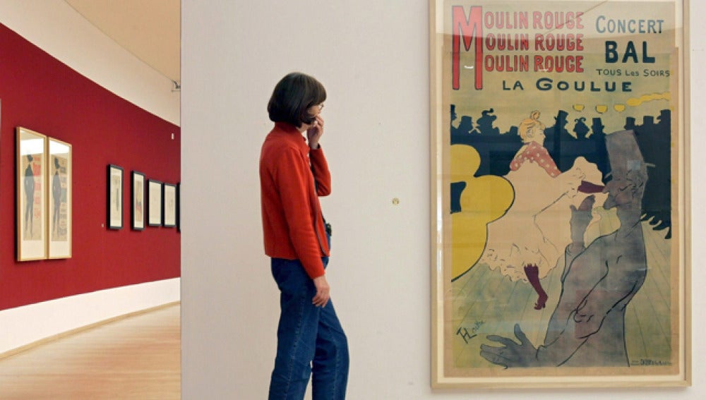 Una mujer contempla la litografía 'Moulin Rouge', de Toulouse-Lautrec