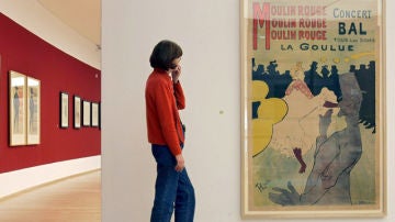 Una mujer contempla la litografía 'Moulin Rouge', de Toulouse-Lautrec