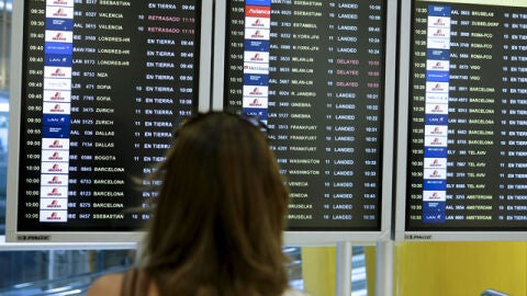 Una mujer observa la pantalla de vuelos en un aeropuerto