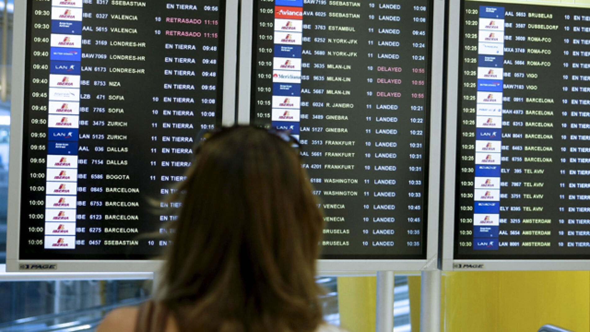 Una mujer observa la pantalla de vuelos en un aeropuerto