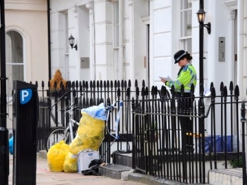 Una policía guarda la casa donde fue encontrado el cuerpo del agente del MI6