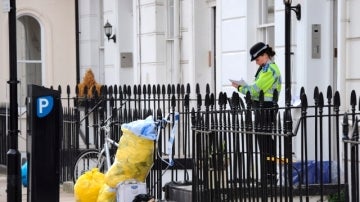 Una policía guarda la casa donde fue encontrado el cuerpo del agente del MI6