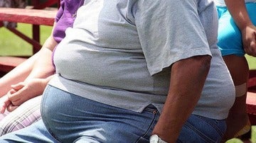Un hombre obeso sentado en un banco