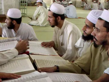 Un grupo de estudiantes leyendo el Corán Un grupo de estudiantes leyendo el Corán