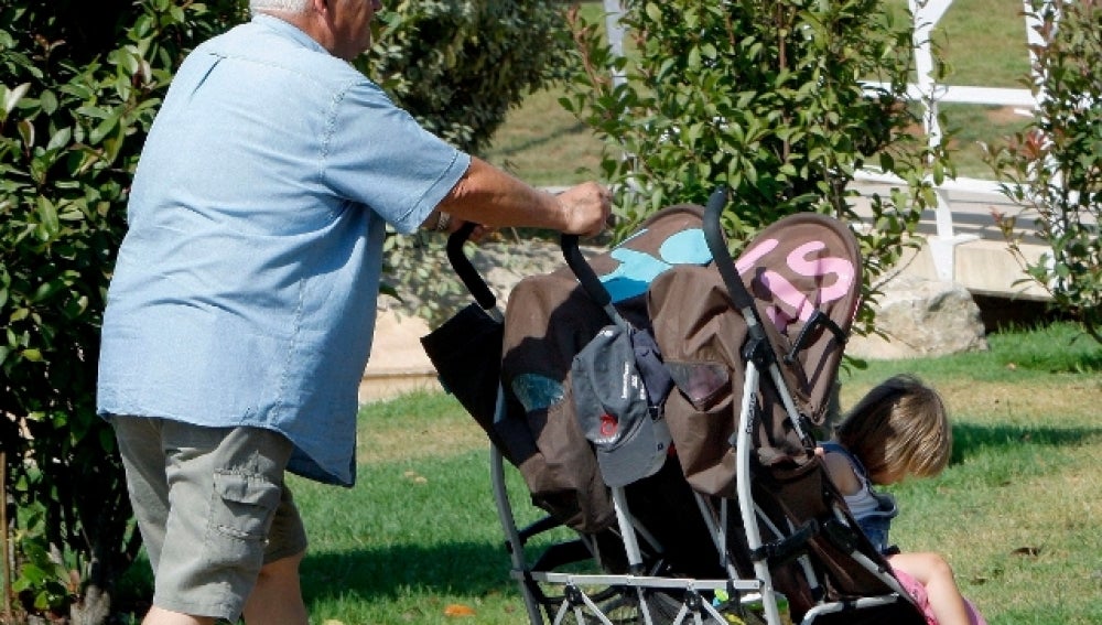 Un abuelo paseando a sus nietos