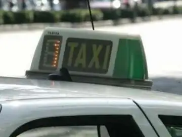 Un taxi espera estacionado en busca de clientes Un taxi espera estacionado en busca de clientes