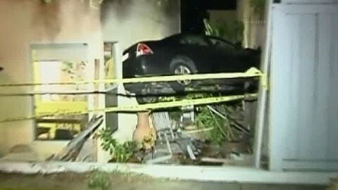 Un coche empotrado entre dos viviendas
