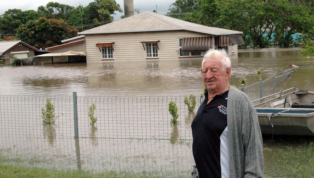 Un hombre frente a su casa inundada en Australia