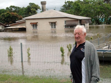 Un hombre frente a su casa inundada en Australia