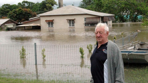 Un hombre frente a su casa inundada en Australia
