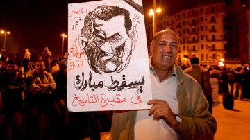 Un hombre muestra un retrato de Hosni Mubarak