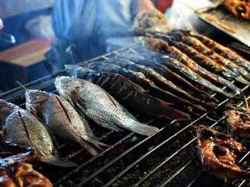 Pescados cocinándose en la parrilla Pescados cocinándose en la parrilla