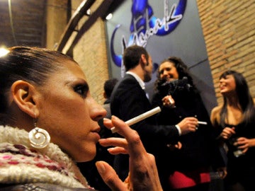 Una joven fuma a las puertas de un pub