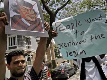 Un joven con un cartel en contra de Gadafi