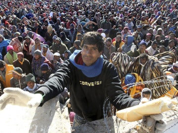 Un voluntario reparte pan entre los refugiados en la frontera