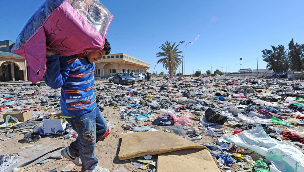Un niño traslada las pertenencias de su familia en Libia (03-03-2011)