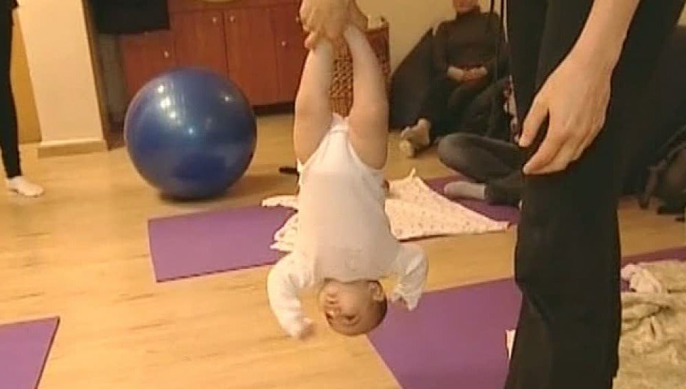 Una madre practica baby yoga con su bebé