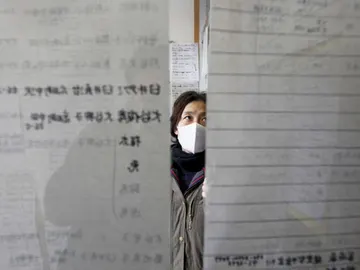 Una mujer busca a un familiar entre los nombres que figuran en las listas de refugiados en la ciudad costera de Rikuzentakata Una mujer busca a un familiar entre los nombres que figuran en las listas de refugiados en la ciudad costera de Rikuzentakata