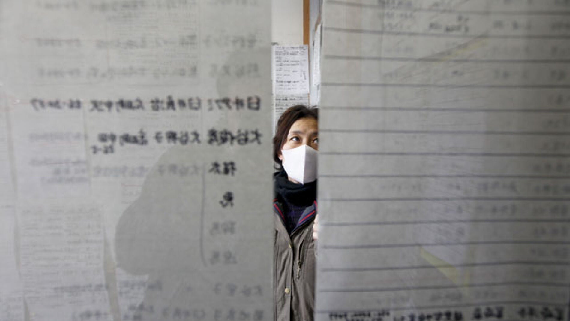 Una mujer busca a un familiar entre los nombres que figuran en las listas de refugiados en la ciudad costera de Rikuzentakata