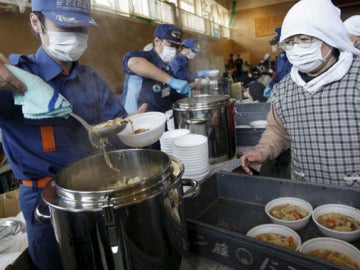 Bomberos sirven raciones de sopa a refugiados