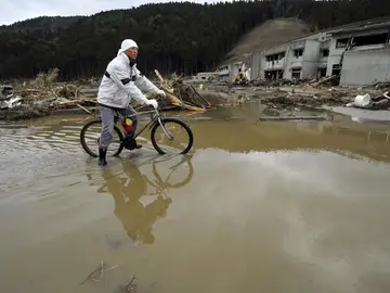 Un hombre conduce su bicicleta frente a la escuela de enseñanza primaria de Okawa Un hombre conduce su bicicleta frente a la escuela de enseñanza primaria de Okawa