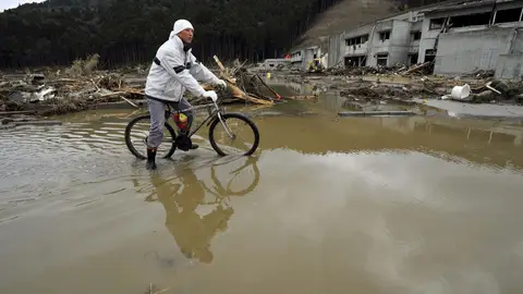 Un hombre conduce su bicicleta frente a la escuela de enseñanza primaria de Okawa Un hombre conduce su bicicleta frente a la escuela de enseñanza primaria de Okawa