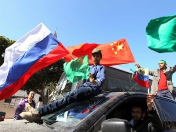 Partidarios de Gadafi ondean la bandera Libia junto a las de China y Rusia